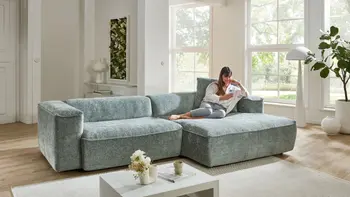 Blaues Sofa in hellem Raum. Frau entspannt am relaxen